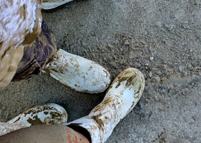Uguali nel fango di Michela Gaudenzi - Due lavoratori nel fango, un uomo e una donna, una madre e un figlio. Fatica, raccapriccio, sgomento: stessi sentimenti dentro quegli stivali. E il fango ingloba tutto.
